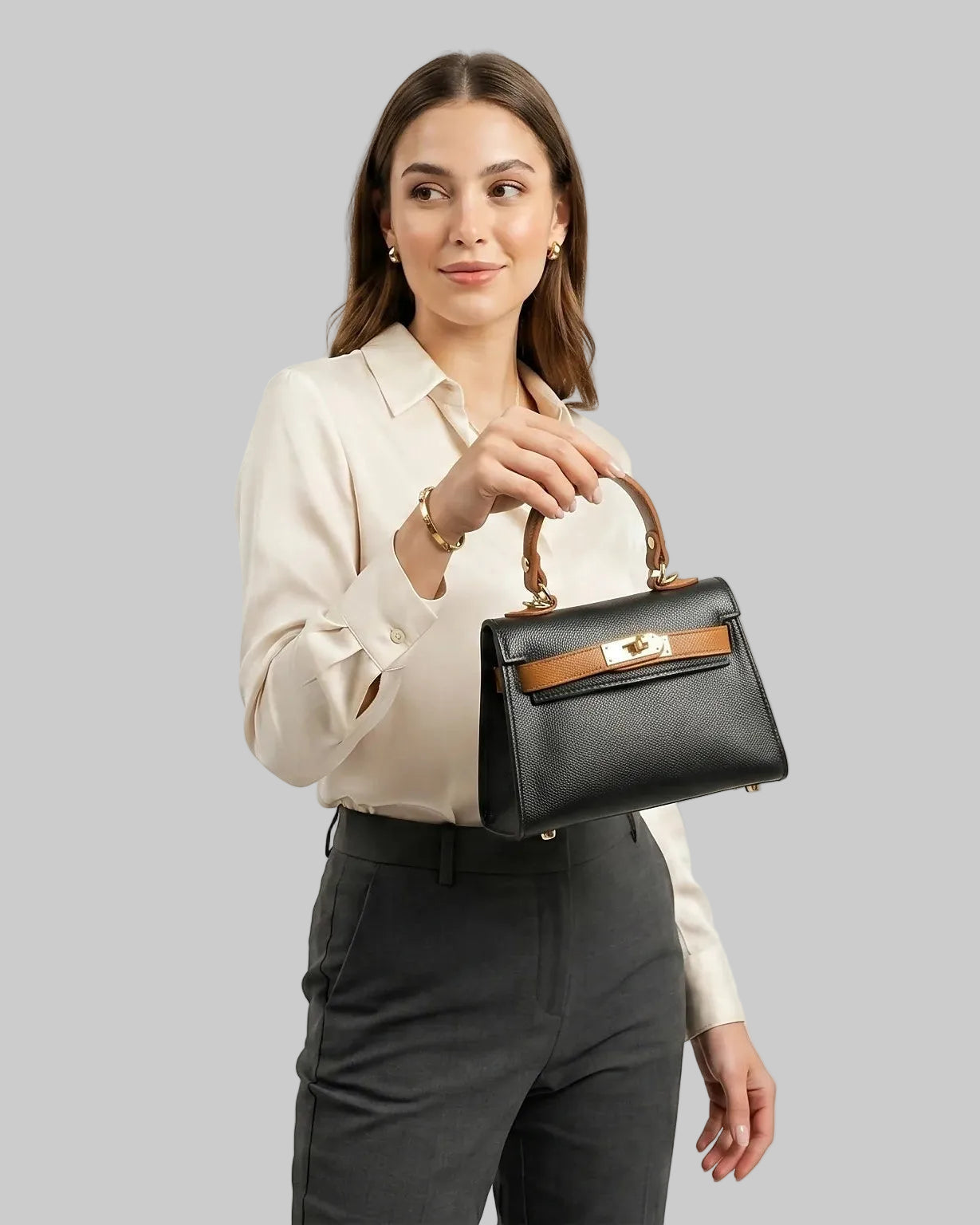 Donna che tiene in mano una mini borsa a mano in pelle nera su sfondo bianco